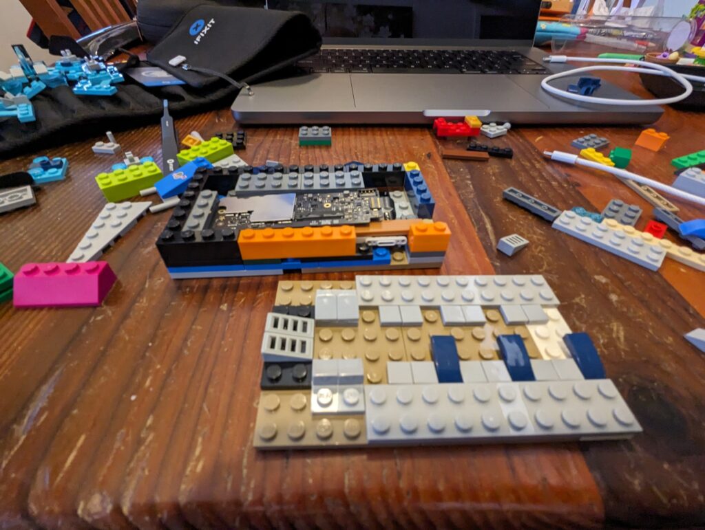 An incomplete Lego enclosure for the Touch ID sensor and control board from an Apple keyboard. 